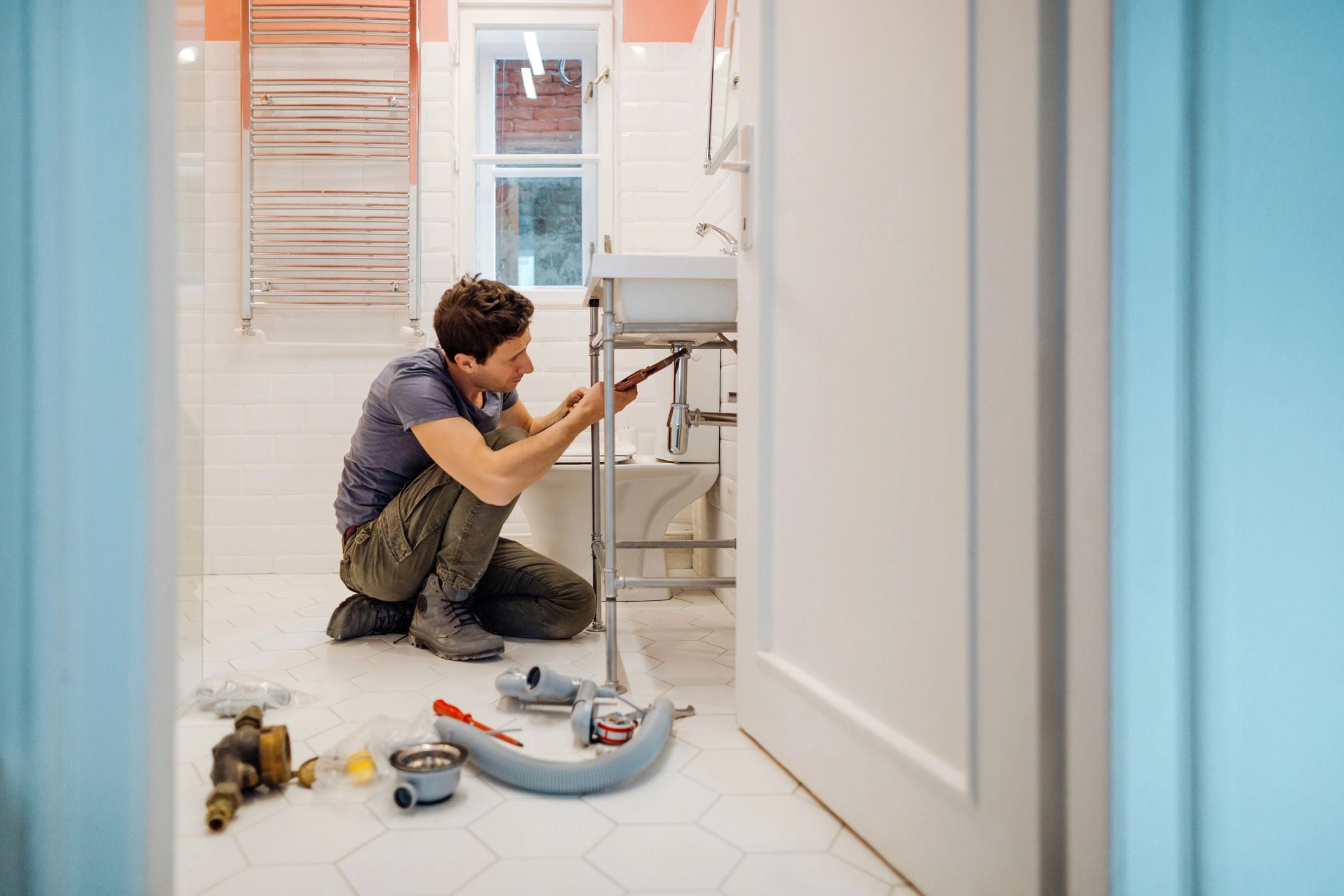 Plumber fixing a leak under a bathroom sink